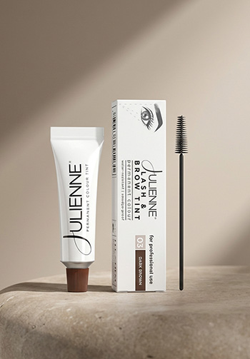 Julienne Beauty product set: white tube with brown cap, boxed packaging with eye motif, and a mascara wand on a beige pedestal.